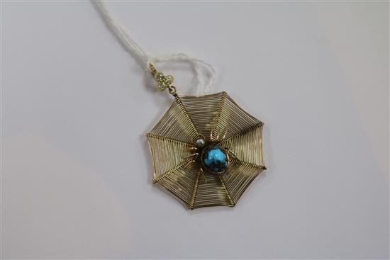 An early 20th century yellow metal spiders web pendant with gem set spider and diamond set bale, 30mm.